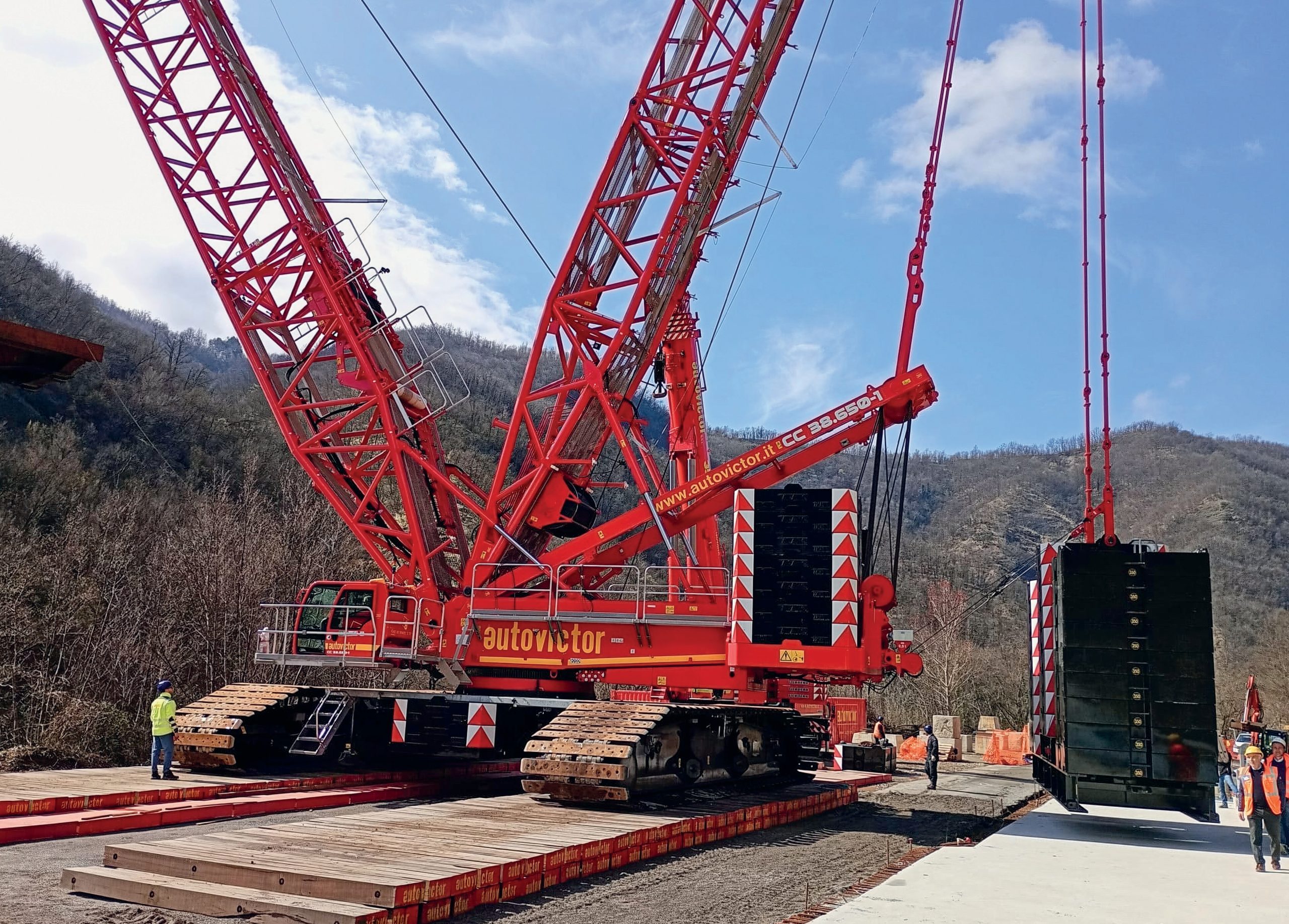 A red crane supported by crane mats