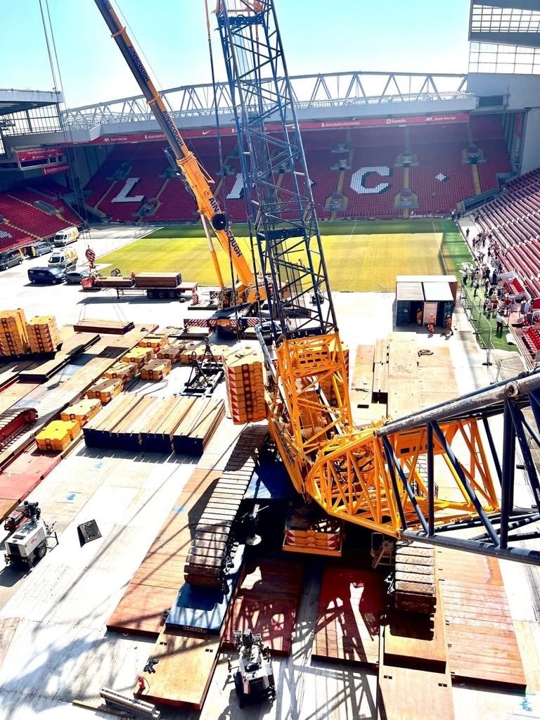 A yellow crane being supported by crane mats at Anfield
